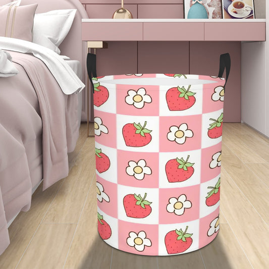 Laundry basket with strawberry and flower pattern on a wooden floor.