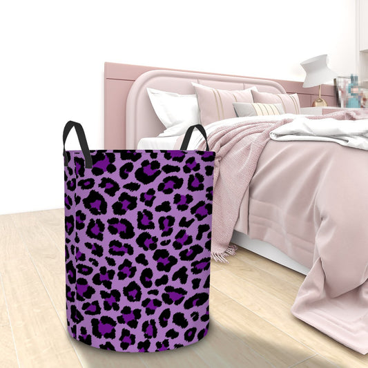 Purple leopard print laundry basket on a wooden floor with a bed in the background